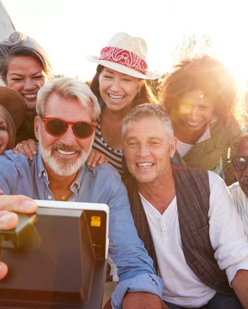 Group Of Mature Friends Posing For Selfie At Outdoor Campsite